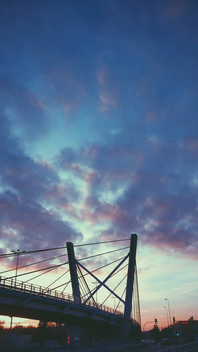 Bridge cables silhouetted beneath a colorful evening sky, W:9 H:16, photograph 28
