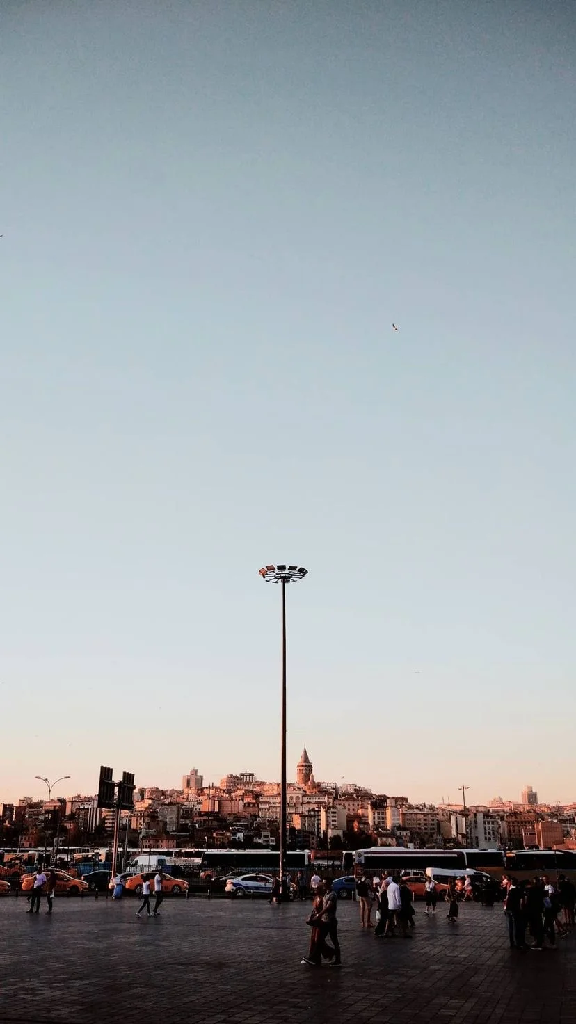 People crossing a wide waterfront square at sunset, W:9 H:16, photograph 25