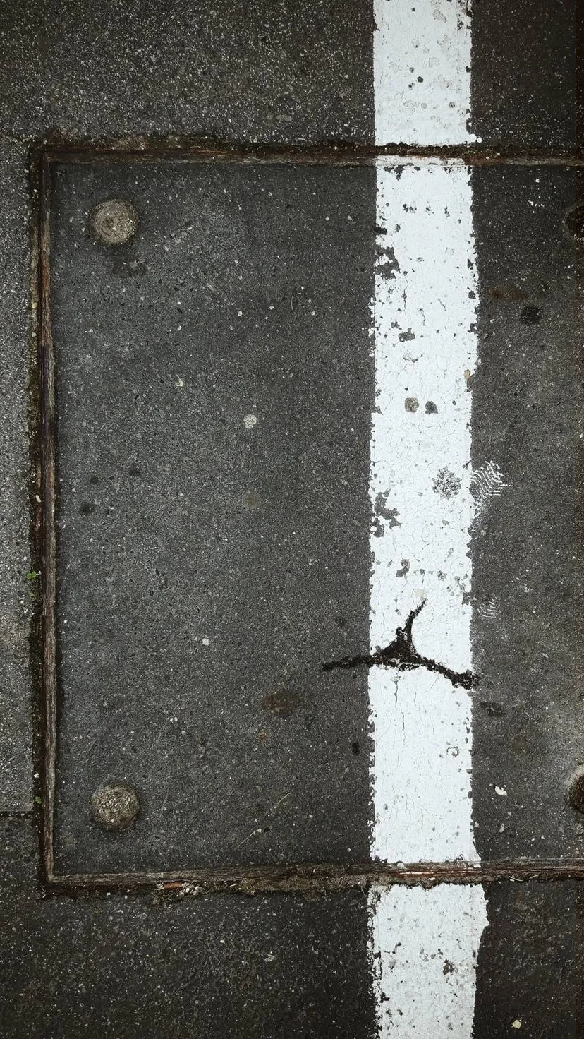 White road marking crossing an asphalt repair, W:9 H:16, photograph 27