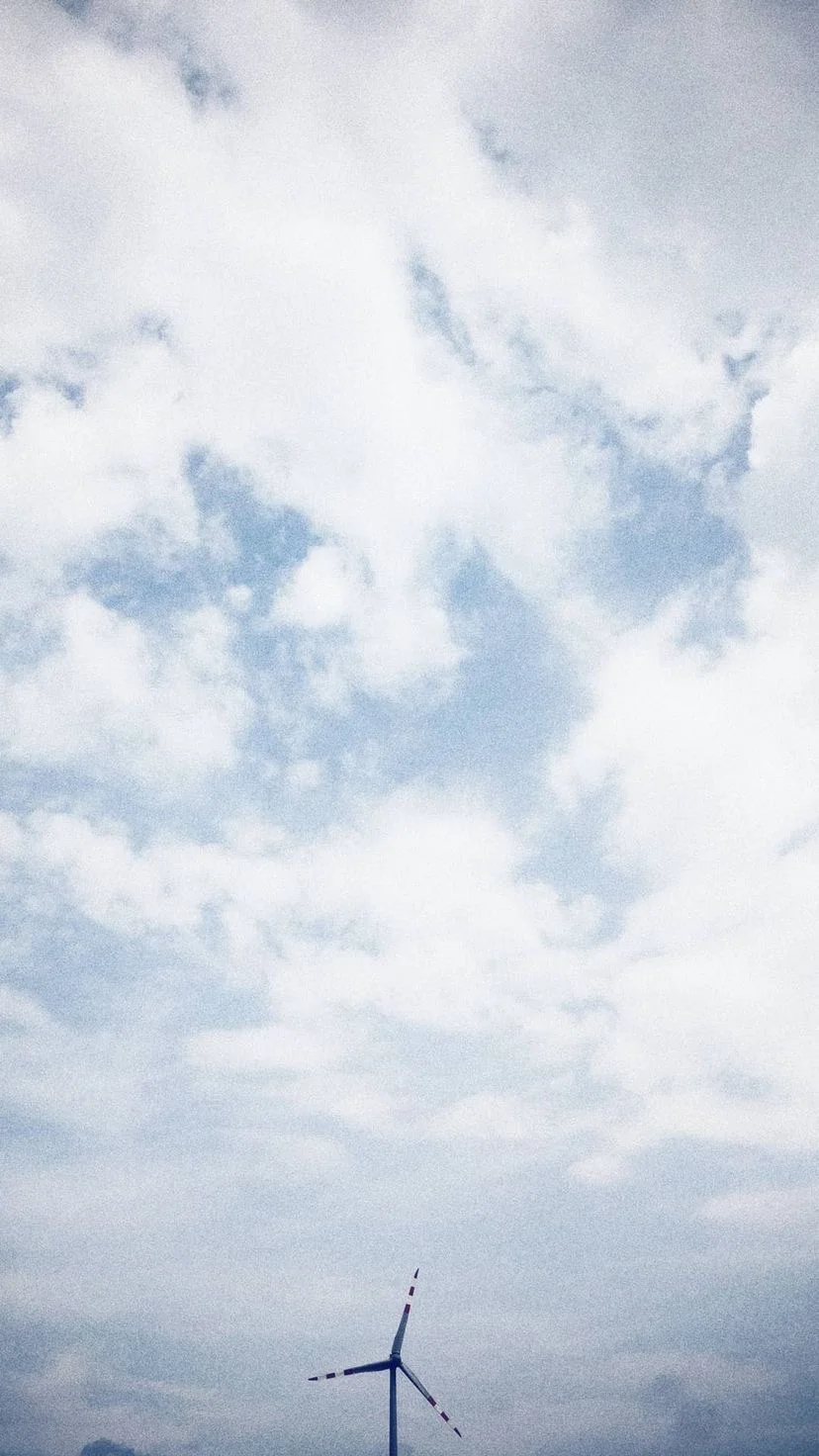 Wind turbine beneath an open cloudy sky, W:9 H:16, photograph 65