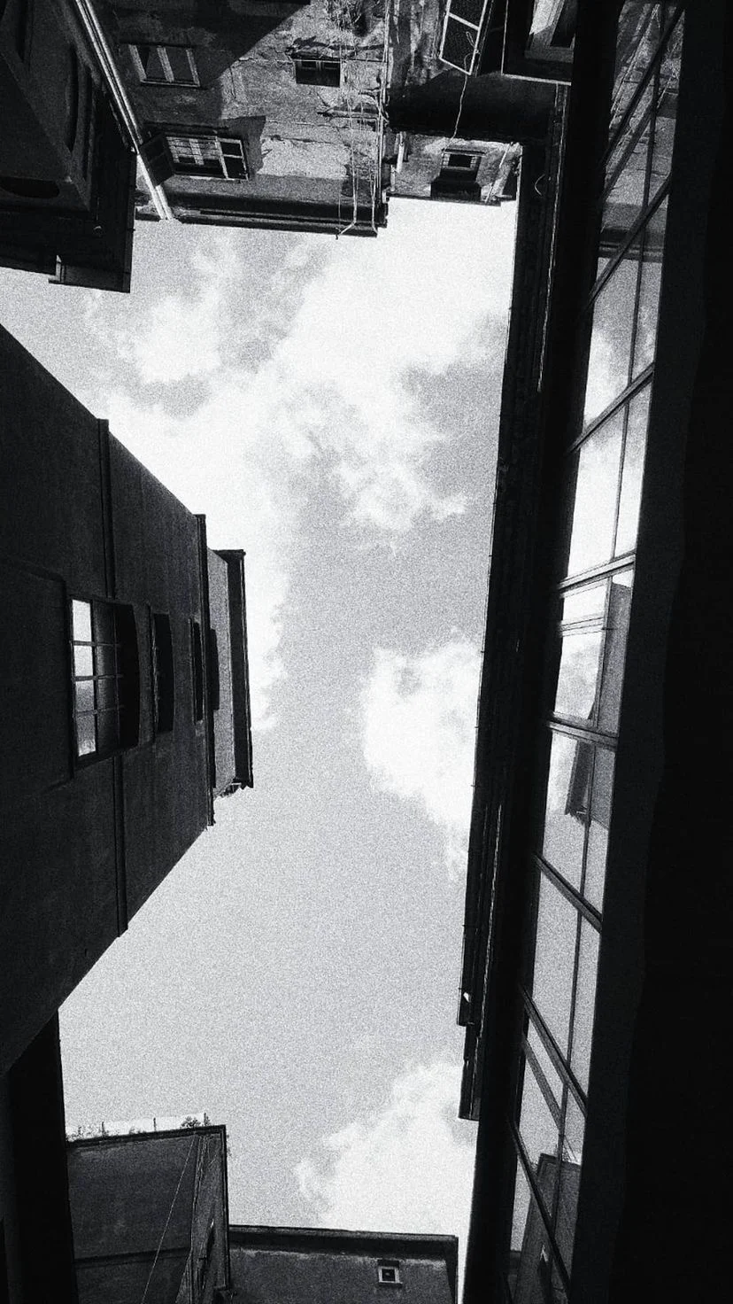 Black and white view of sky between close buildings, W:9 H:16, photograph 32