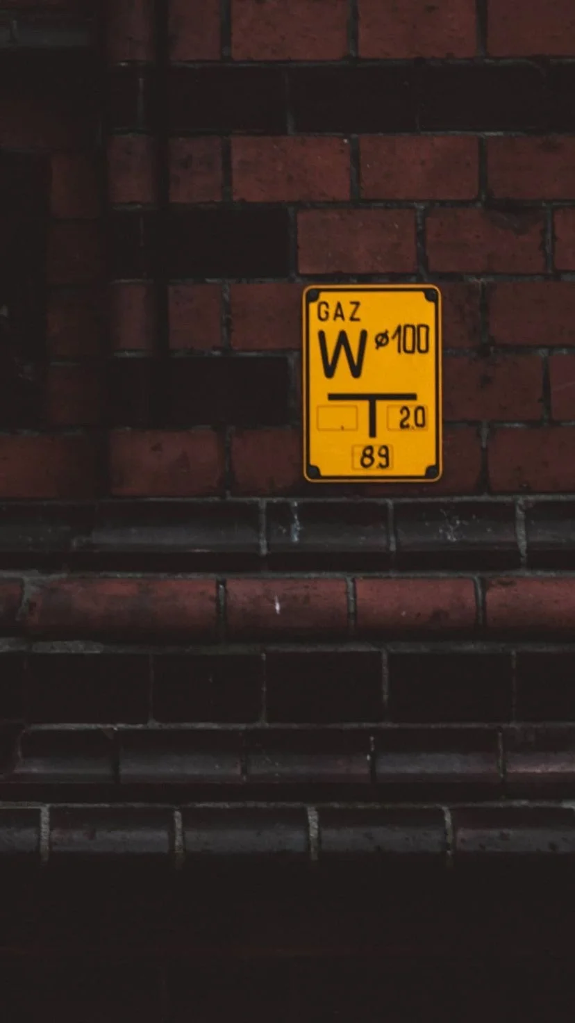Yellow utility sign against dark brick, W:9 H:16, photograph 5