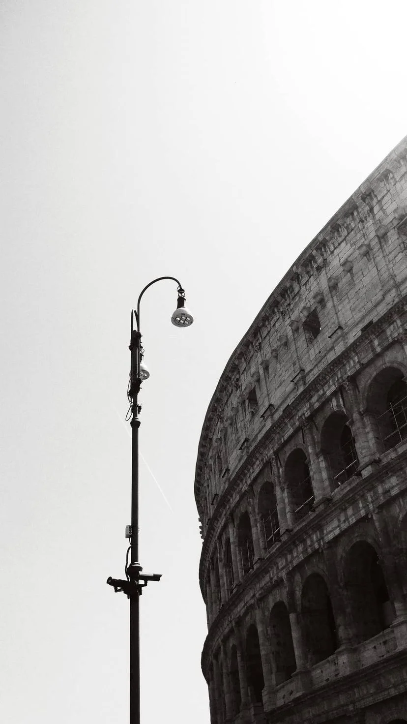 Black and white view of a curved stone facade and streetlamp, W:9 H:16, photograph 37